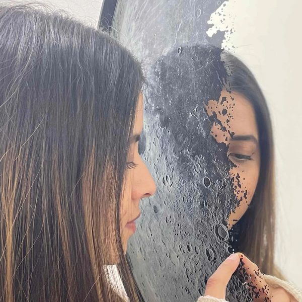 Woman admiring Moon-inspired mirror